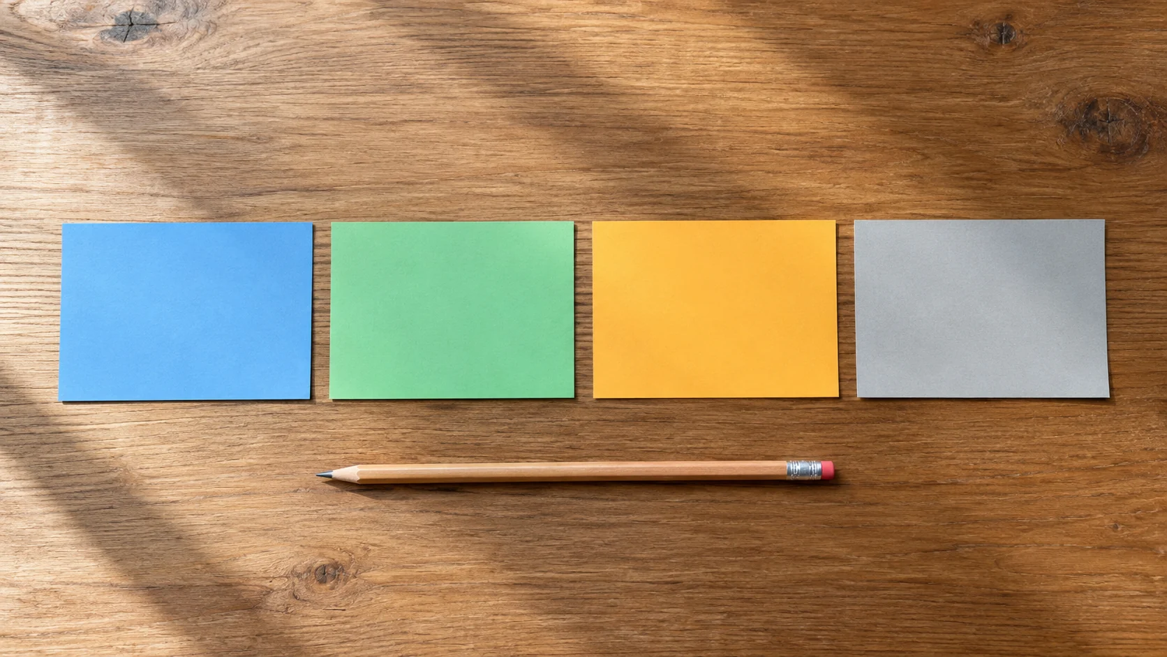 Four blank colored index cards and a pencil on a study desk
